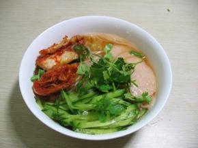 放上事先准备好的辣白菜，黄瓜，香菜和泡好的粉肠，在放一些辣椒油