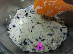 倒入过筛的低粉，用刮刀采用切拌或翻拌方式，把面粉跟打好的黄油混合至无干粉状态。