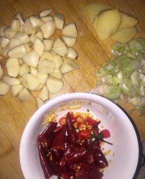  辣椒切两半，小米椒切碎段，黄瓜削皮去芯。蒜切段，姜切片，葱切碎。