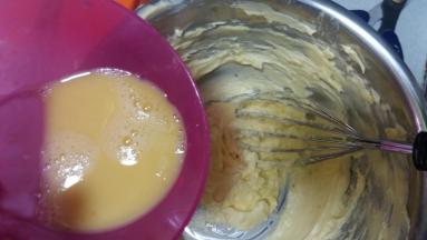 分次少量将蛋液倒入打发的黄油中，每次混合均匀后再加入余下的蛋液