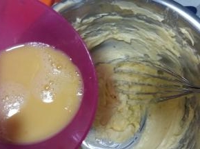 分次少量将蛋液倒入打发的黄油中，每次混合均匀后再加入余下的蛋液