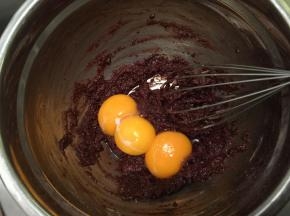 加入牛奶油混合物，拌至无干粉后磕入蛋黄