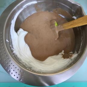 将拌好的蛋糕糊倒入到剩余的蛋白霜中，翻拌均匀。