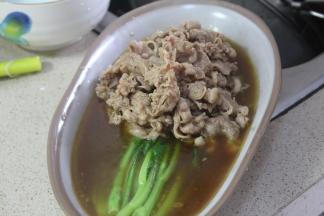 将煮好的芥兰放置盘内，肥牛放入芥兰上，倒入汁水