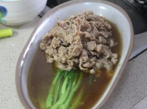 将煮好的芥兰放置盘内，肥牛放入芥兰上，倒入汁水