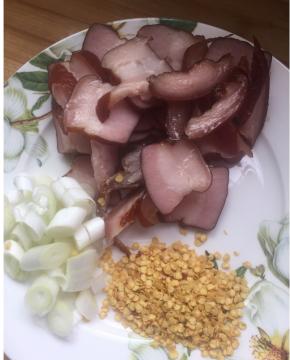 腊肉切片，保证口感，不需要太薄，两毫米左右的片，准备辣椒，或者辣椒籽，葱花