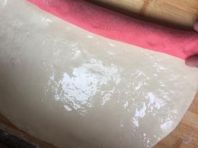 . 红色铺底下，红色面片上刷油，白色铺上面，白色上面也刷油，然后卷起来。