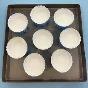 将拌好的蛋糕糊装入裱花袋中，分装入纸杯中，8分满，再稍微震几下，震出大气泡。