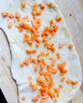 擀成大片，刷蛋液，放点胡萝卜碎