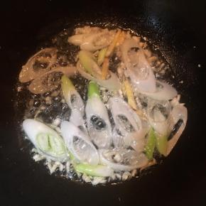 锅中加入油，大火烧热，放入蒜末，姜丝和1/3的大葱，煸出香味。