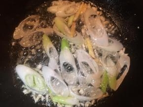 锅中加入油，大火烧热，放入蒜末，姜丝和1/3的大葱，煸出香味。