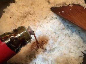 加入事先煮熟打散的米饭，淋入酱油翻炒均匀。