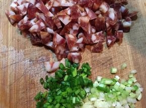 腊肠用开水烫洗一下切丁，香葱和蒜头切末。