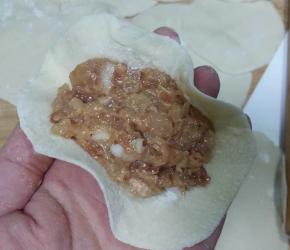 取一饺子皮，放适量馅料；