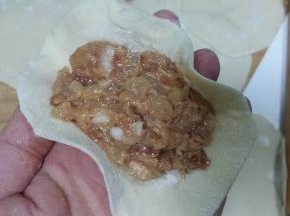 取一饺子皮，放适量馅料；