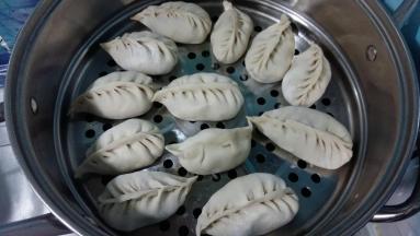 内注入凉水，蒸屉刷油或垫屉布。把包好的饺子放上面，因是半烫面，不会醒发，挨着放就行。