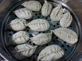 内注入凉水，蒸屉刷油或垫屉布。把包好的饺子放上面，因是半烫面，不会醒发，挨着放就行。