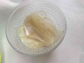 吉利丁片提前用冰水泡软，泡软的吉利丁片沥干水分，放入牛奶中，隔热水融化