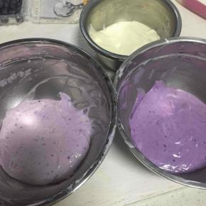 混合均匀的芝士糊，分成三份，其中两份分别加入适量的蓝莓酱，调成不同颜色，（蓝莓酱一点一点加，以免其中一份上色太深，看不出层次）