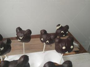 蛋糕插入棒子，黑巧克力隔水融化，淋在蛋糕体的表面，晾干后装饰表情。