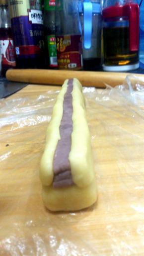 在抹茶面团两侧粘上兔子耳朵（两份21克原味面团），同样压实弄平整；