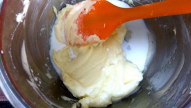 牛奶分次加入，用刮刀或手动打蛋器轻轻搅匀，不要用力搅拌以免黄油被打发；