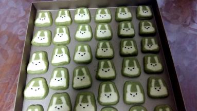 取出冷冻好的面团，切成5MM宽的薄片；放在烤盘上，取适量蜂蜜，用少许化开。然后用筷子沾水，在兔子脸上点黑芝麻。点成“八字形”会更萌哦。面团一定要冻硬再切，否则兔子会变形。如果觉得切完兔子形状不好看，没关系，把饼干放烤盘上，面稍微软点手动微整形就好；