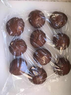 取出面团揉排气，分成大约50克一个的面团，大约分了10个，揉圆，盖保鲜膜醒面15分钟。把面团按扁，包入10克巧克力豆，德芙巧克力也可以。