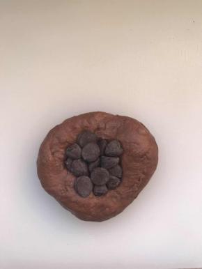 把面团按扁，包入10克巧克力豆，德芙巧克力也可以。