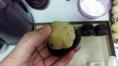 包制：取出冷藏好的面团，分成30份，开始包制月饼。牚心沾少许手粉，将面团放在掌心上，轻压成圆饼状，把馅料放上面；