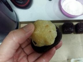 包制：取出冷藏好的面团，分成30份，开始包制月饼。牚心沾少许手粉，将面团放在掌心上，轻压成圆饼状，把馅料放上面；