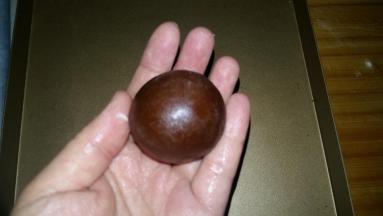 包制：左手大拇指轻压馅料顶部，右手的大拇指和食指从面皮底部以转圈方工慢慢向上推；合拢收口捏紧，再沾少许手粉，搓圆，月饼生坯就做成啦； .