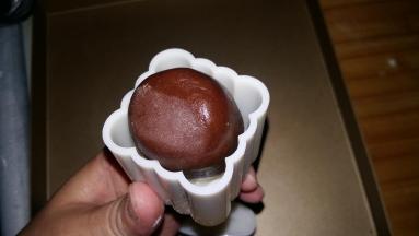 包制：月饼生坯放进模具，左手按住月饼底部，倒扣在案板上，右手将模具手柄均匀用力压下。