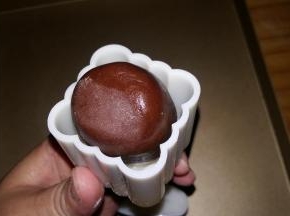 包制：月饼生坯放进模具，左手按住月饼底部，倒扣在案板上，右手将模具手柄均匀用力压下。