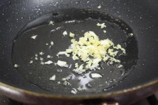 锅内烧油，先加蒜、姜炒味，粉丝入锅进行翻炒