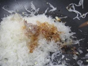 加洋葱粒、虾仁，用小火慢慢炒粉丝，将粉丝的水分炒干