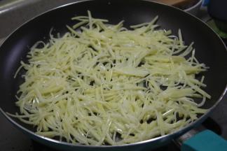 土豆丝一点点的，均匀的平铺在锅里，用小火煎