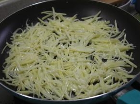 土豆丝一点点的，均匀的平铺在锅里，用小火煎