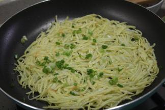 将按压好的饼煎至两边金黄酥脆，便可撒上葱花