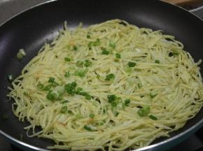 将按压好的饼煎至两边金黄酥脆，便可撒上葱花