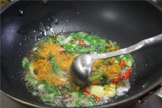 锅内倒入适量的油，油温烧热之后放入切好的底料炒香，然后放入1勺黄灯笼辣椒酱