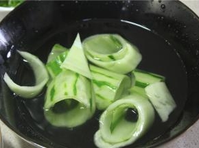 片下来的黄瓜片卷成筒状，放入冷水中浸泡一下，浸泡可以让黄瓜片的口感变的更加清脆