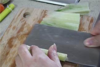 用手压着黄瓜，滚刀贴着黄瓜芯将表皮片成片状