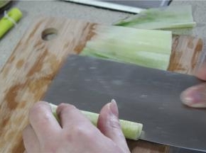 用手压着黄瓜，滚刀贴着黄瓜芯将表皮片成片状