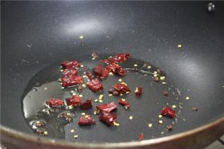 锅内加少许的油，烧热之后放入切好的干辣椒段，小火炒出香味