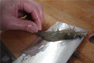 虾从头用刀剖至尾部，但尾部不断，剖成两半，去掉虾线