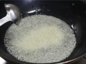 锅内倒入多一点的食用油，烧至二层油温的时候取三分之二的蒜放入锅内