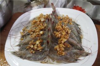 虾肉上放上调好的金银蒜。将虾肉朝上，蒜茸放上去可以更入味，而且蒸出来的虾也不会卷曲