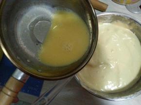 将牛奶黄油混合物顺着刮刀面慢慢倒入蛋糕糊中