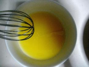 橙汁与玉米油混合，用手动打蛋器将两者打至完全溶合；